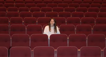 Ashley Dawson poses for a photo in an empty theatre