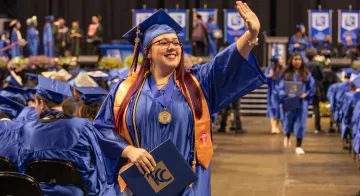 Shenoah Lyons waves after she receives her degree