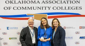 Angela Sivadon, Mary Cantrell, and Leigh Goodson are smiling while Cantrell is holding a Hall of Fame trophy.