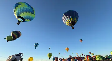 Several colorful hot air balloons lift off at the Albuquerque Balloon Fiesta