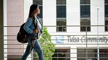 Student outside on the balcony walking to class at TCC Metro Campus