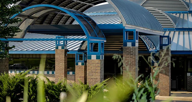 TCC Northeast Campus archway in with vegetation in the foreground.