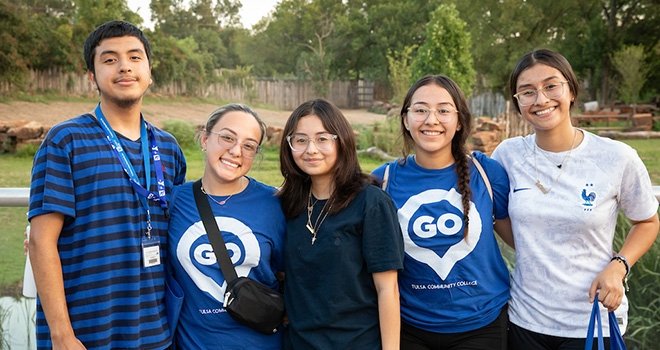 Group of five students pose together