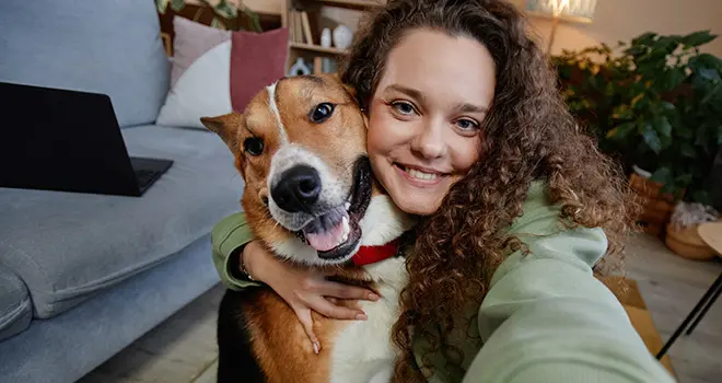 Young woman poses for a selfie with a dog