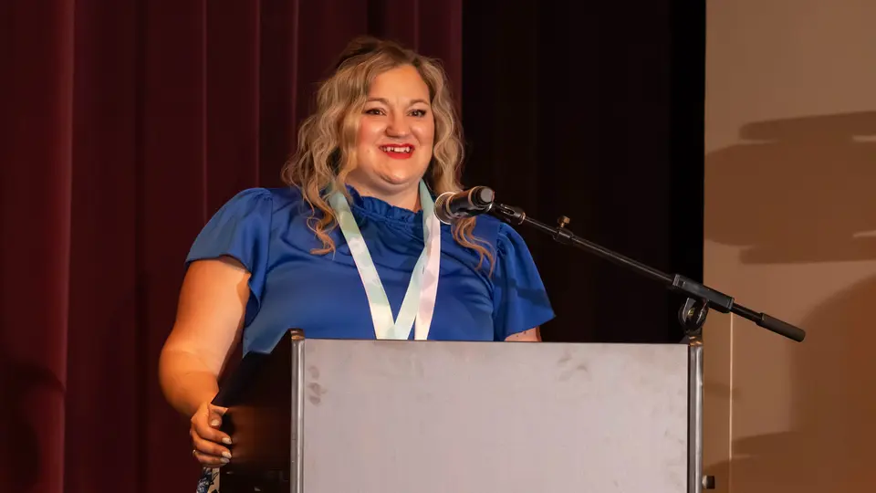 Crystal Bickle stands at podium to lead students and faculty in the Nightingale Pledge.