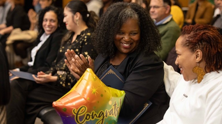 Marvina Larry claps during the Cyber Skills Center graduation ceremony