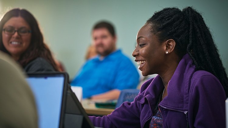 Young black female smiles while participating in class at TCC.
