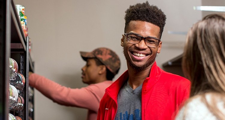 Young black TCC student smiles in TCC food pantry