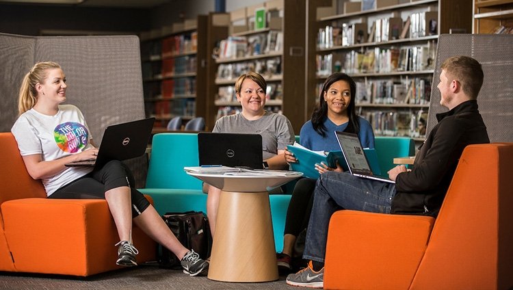 Four TCC students study together in a library space