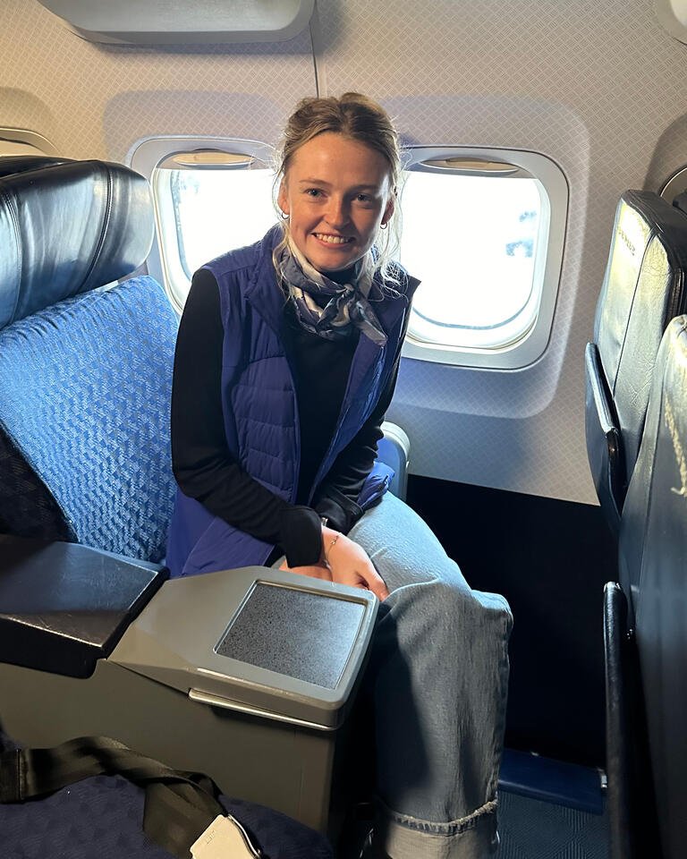 Rebecca Nobles is seated as a passenger inside an airplane