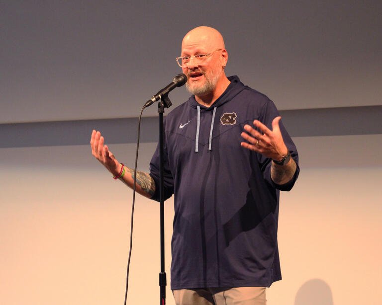 Joshua Baker speaks on stage