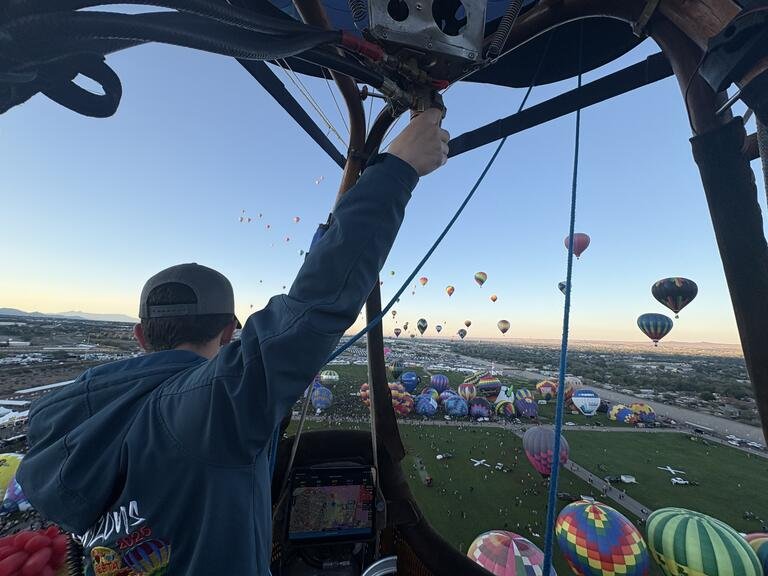 Baylor Rodden flies his hot air balloon in the air. The view is from Rodden's balloon basket.